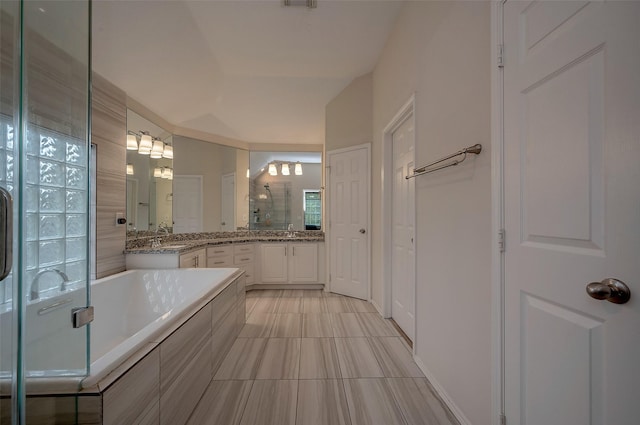 bathroom with vaulted ceiling, separate shower and tub, and vanity