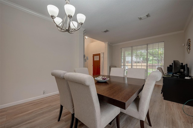 dining space with a notable chandelier, crown molding, a textured ceiling, and light hardwood / wood-style flooring