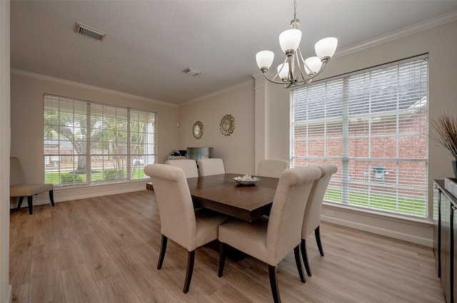 dining area featuring a notable chandelier, ornamental molding, and light hardwood / wood-style floors