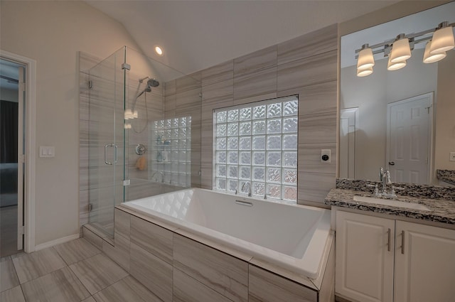 bathroom with plus walk in shower, vaulted ceiling, and vanity