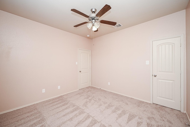 empty room featuring ceiling fan and light colored carpet