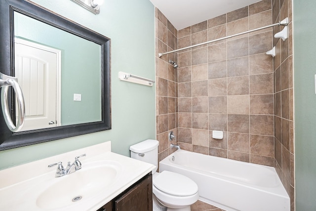 full bathroom featuring toilet, tiled shower / bath, and vanity