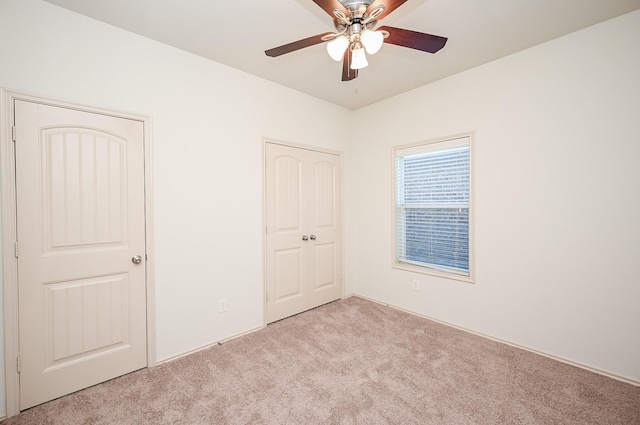 unfurnished bedroom featuring light carpet, ceiling fan, and a closet