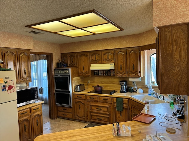 kitchen featuring a textured ceiling, sink, and black appliances