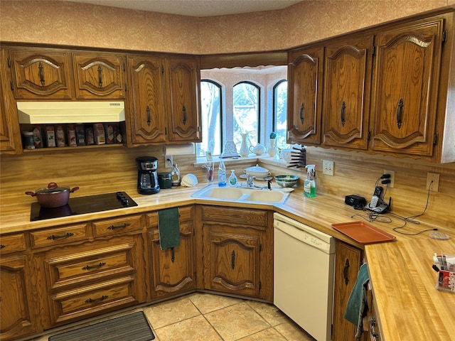 kitchen featuring sink, white dishwasher, black electric cooktop, and light tile patterned flooring