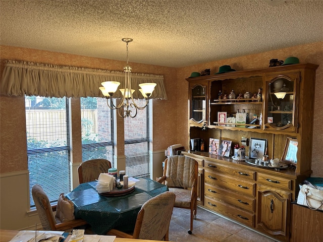 tiled dining area with a textured ceiling and a chandelier