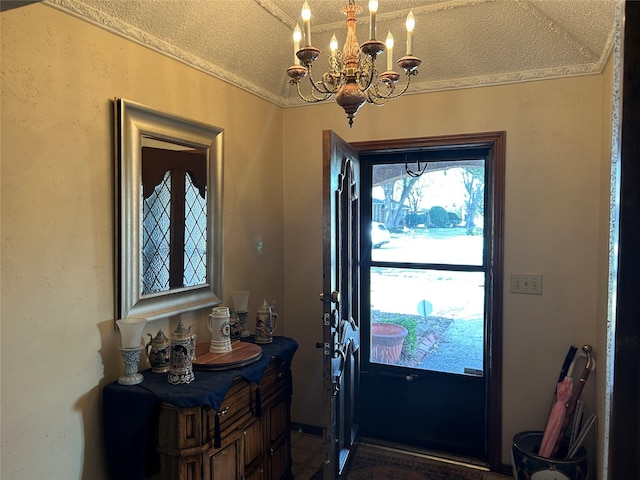 foyer entrance featuring a textured ceiling and a notable chandelier