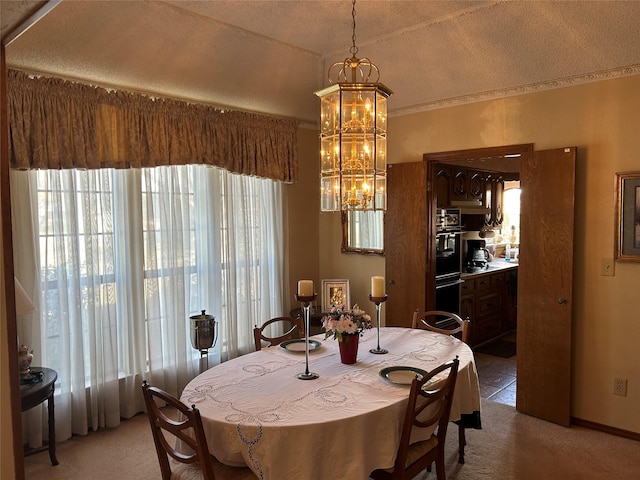 carpeted dining room featuring a textured ceiling and an inviting chandelier