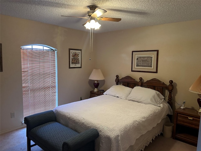 carpeted bedroom with ceiling fan and a textured ceiling