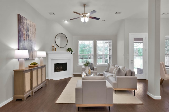 living room featuring dark hardwood / wood-style flooring, a wealth of natural light, ceiling fan, and vaulted ceiling