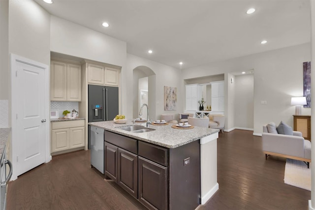 kitchen featuring high end fridge, sink, dark hardwood / wood-style flooring, dishwasher, and a kitchen island with sink