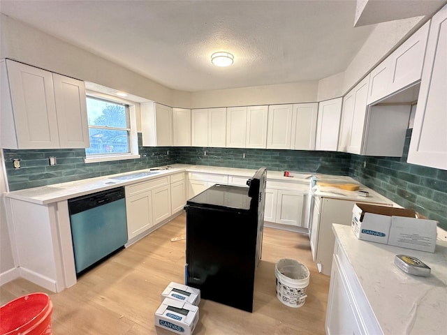 kitchen featuring white cabinets, stainless steel dishwasher, sink, and light wood-type flooring