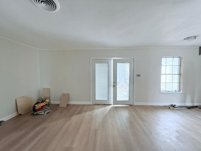 unfurnished room with french doors and light hardwood / wood-style flooring