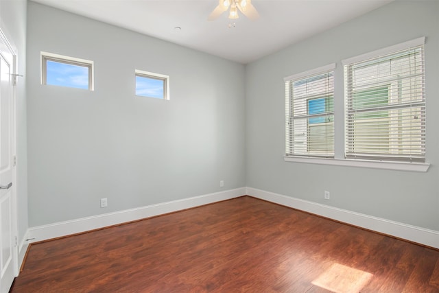 spare room featuring ceiling fan, a healthy amount of sunlight, and dark hardwood / wood-style floors