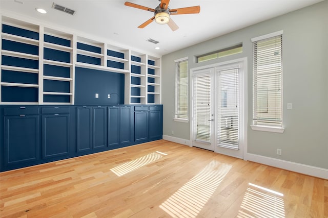 interior space featuring ceiling fan, built in shelves, light hardwood / wood-style flooring, and french doors