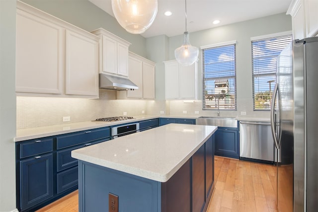 kitchen with decorative light fixtures, a kitchen island, stainless steel appliances, white cabinets, and blue cabinets