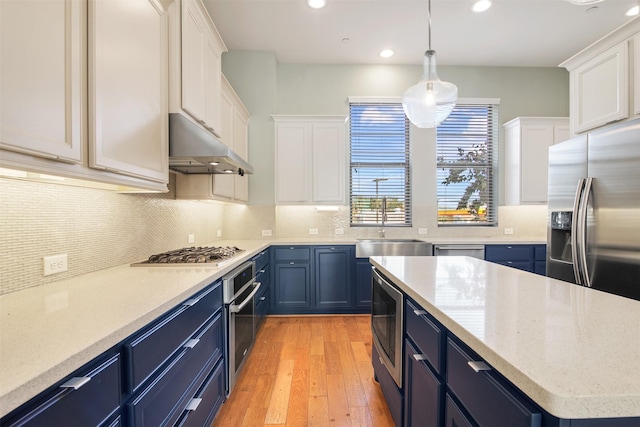 kitchen featuring hanging light fixtures, white cabinets, stainless steel appliances, and blue cabinets