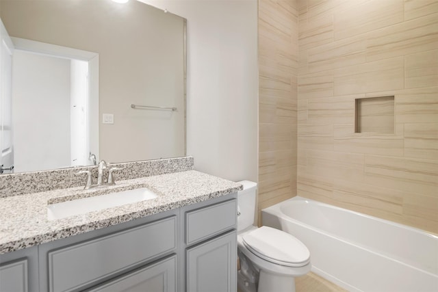 full bathroom with toilet, vanity, and tiled shower / bath