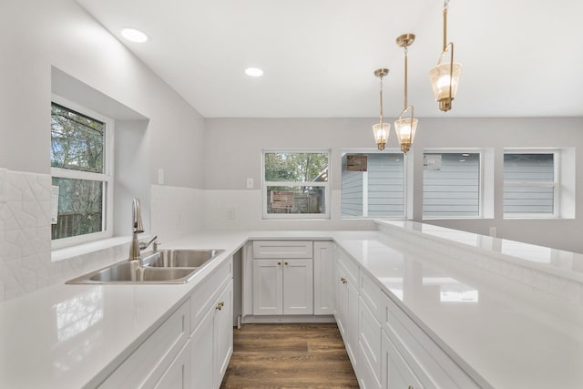 kitchen with tasteful backsplash, sink, hanging light fixtures, a healthy amount of sunlight, and white cabinets