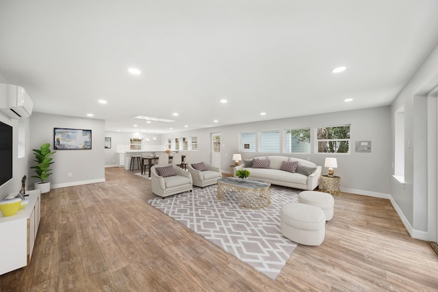 living room with a wall mounted AC and light wood-type flooring