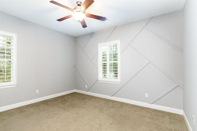 carpeted empty room featuring ceiling fan and a healthy amount of sunlight