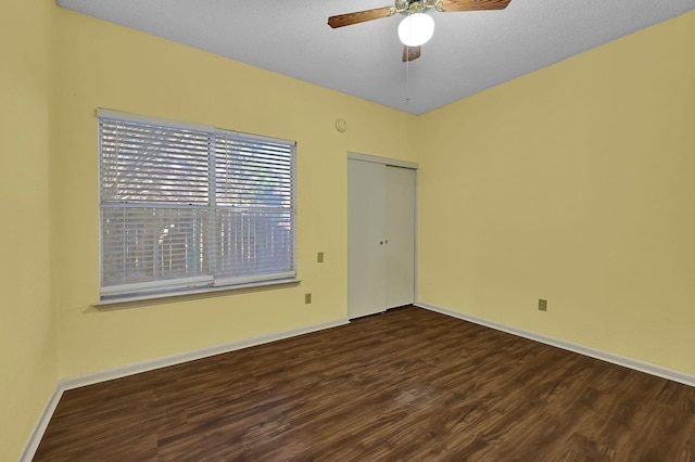 unfurnished room featuring ceiling fan and dark wood-type flooring