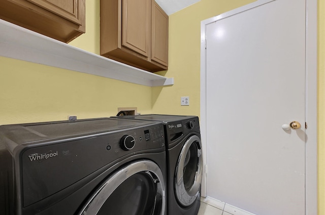 clothes washing area featuring cabinets, light tile patterned floors, and independent washer and dryer