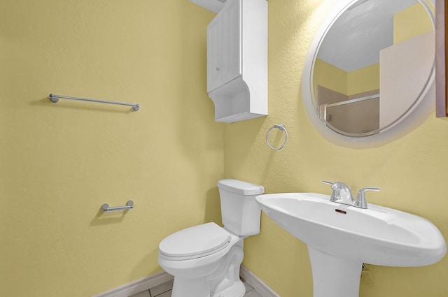 bathroom featuring toilet, sink, and tile patterned floors