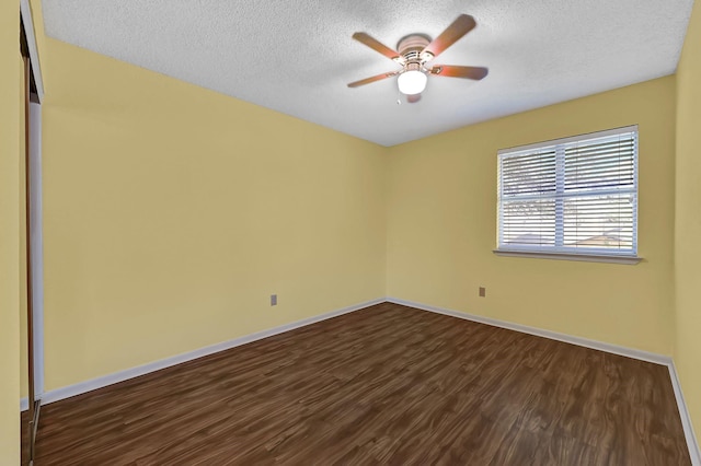 empty room with a textured ceiling, ceiling fan, and dark hardwood / wood-style flooring