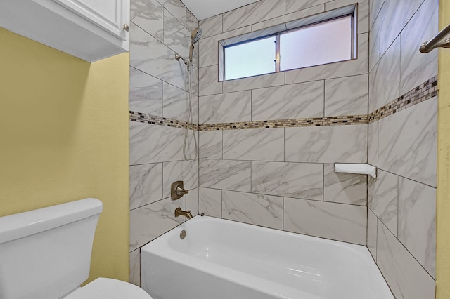 bathroom with toilet and tiled shower / bath