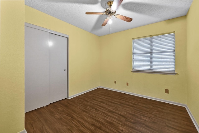 unfurnished room featuring ceiling fan, dark hardwood / wood-style flooring, and a textured ceiling