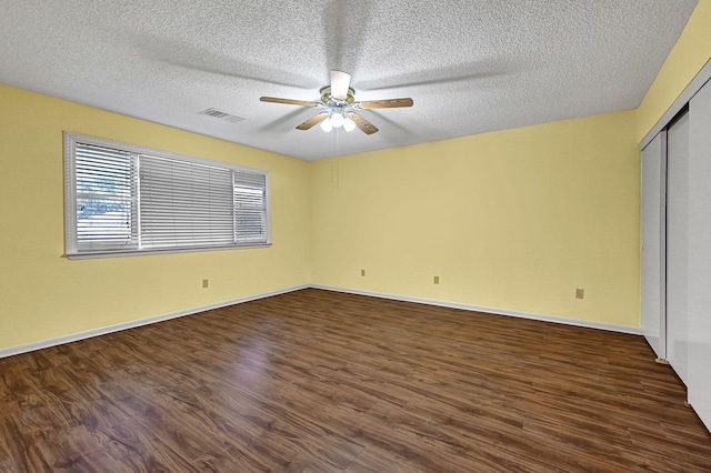 unfurnished bedroom featuring ceiling fan, dark hardwood / wood-style floors, and a textured ceiling