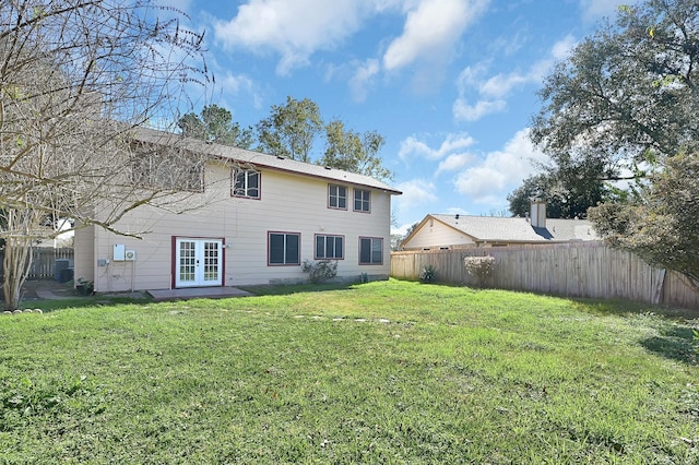 back of property featuring french doors and a lawn