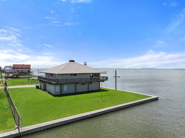 back of house featuring a yard and a water view