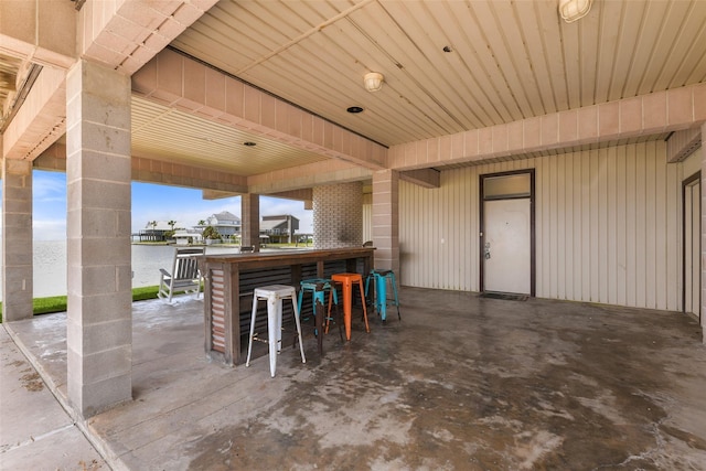 view of patio featuring a water view and a bar