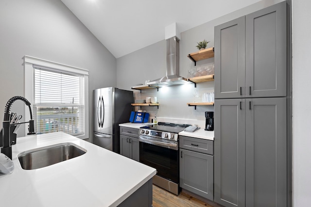 kitchen with extractor fan, stainless steel appliances, gray cabinetry, lofted ceiling, and sink