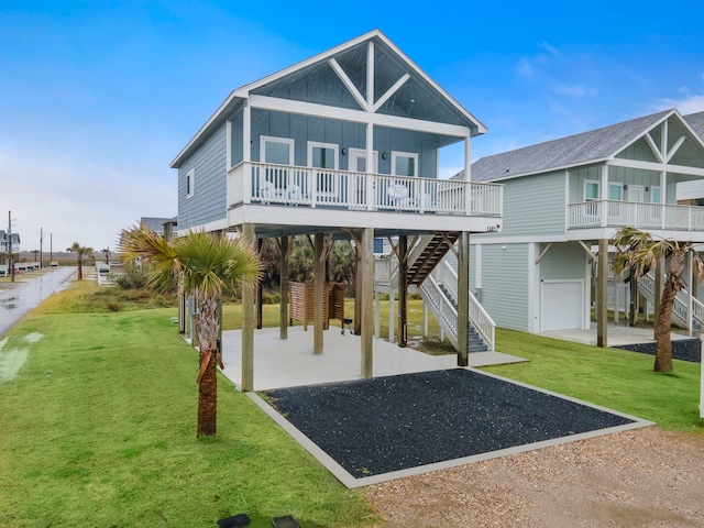 rear view of property featuring covered porch, a garage, and a yard