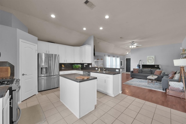 kitchen with white cabinetry, ceiling fan, appliances with stainless steel finishes, light tile patterned flooring, and vaulted ceiling