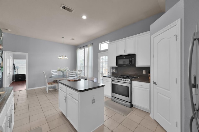 kitchen with gas stove, backsplash, decorative light fixtures, white cabinets, and a center island