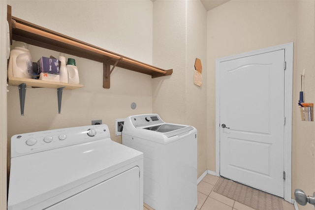 laundry room with light tile patterned floors and washing machine and clothes dryer