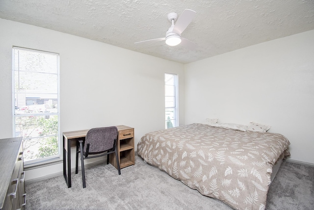 carpeted bedroom with a textured ceiling and ceiling fan