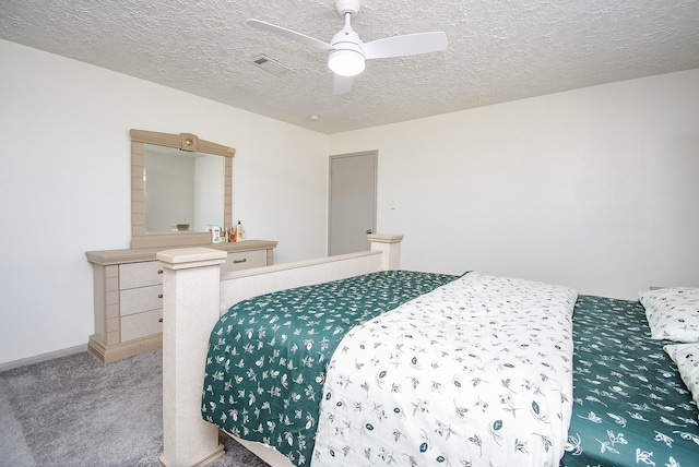 carpeted bedroom with ceiling fan and a textured ceiling