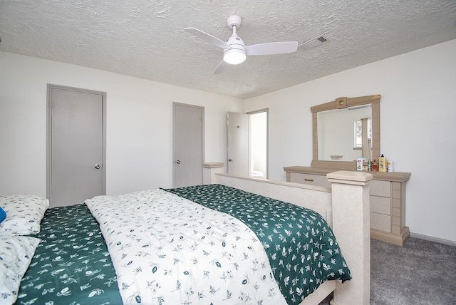 carpeted bedroom featuring ceiling fan and a textured ceiling