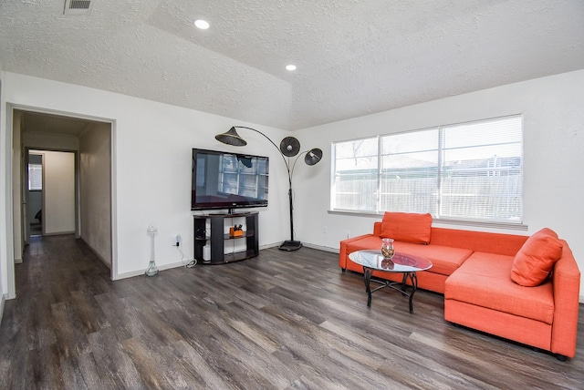 living room with dark wood-type flooring, a textured ceiling, and vaulted ceiling