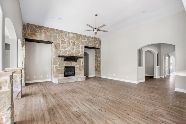 unfurnished living room with ceiling fan, a fireplace, and hardwood / wood-style flooring