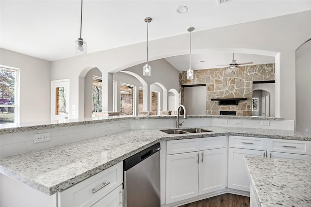 kitchen featuring white cabinets, dishwasher, sink, ceiling fan, and light stone counters