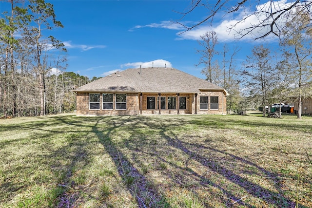 rear view of property featuring a lawn