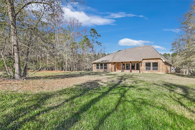 back of property featuring a yard