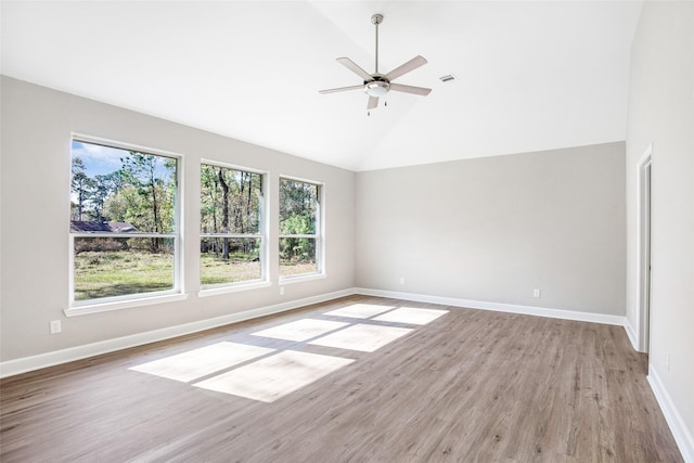 empty room with ceiling fan, high vaulted ceiling, and light hardwood / wood-style flooring