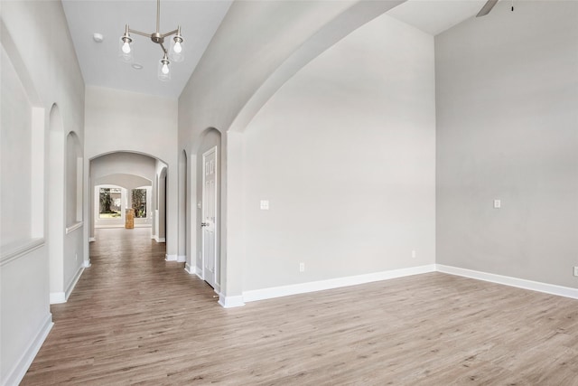 hallway featuring light hardwood / wood-style flooring and a towering ceiling